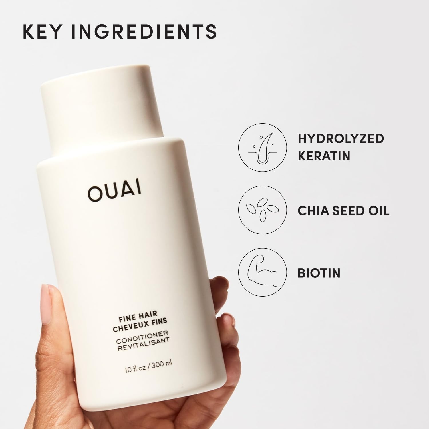 OUAI conditioner next to hand showing true 10 oz size and scale