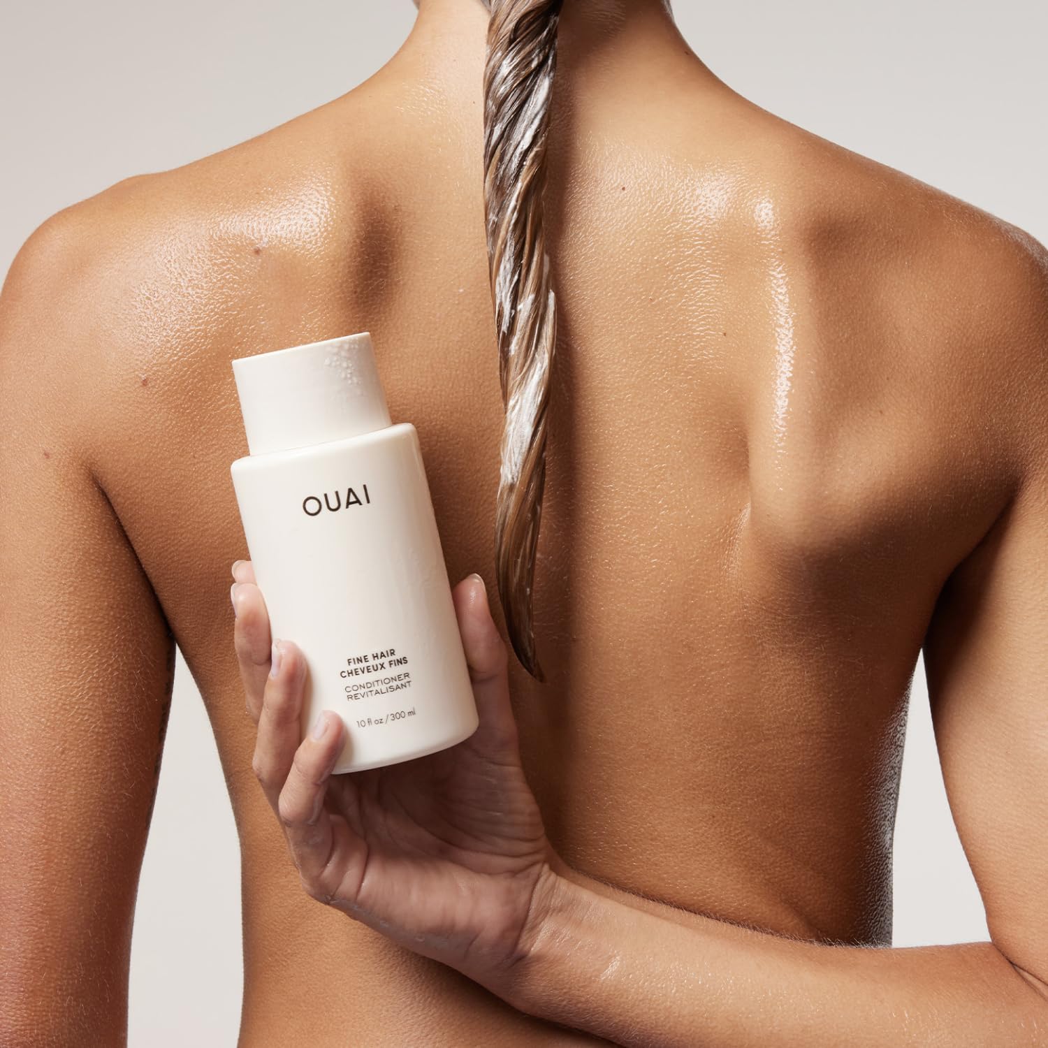 OUAI creamy conditioner texture on palm showing lightweight hydration benefit