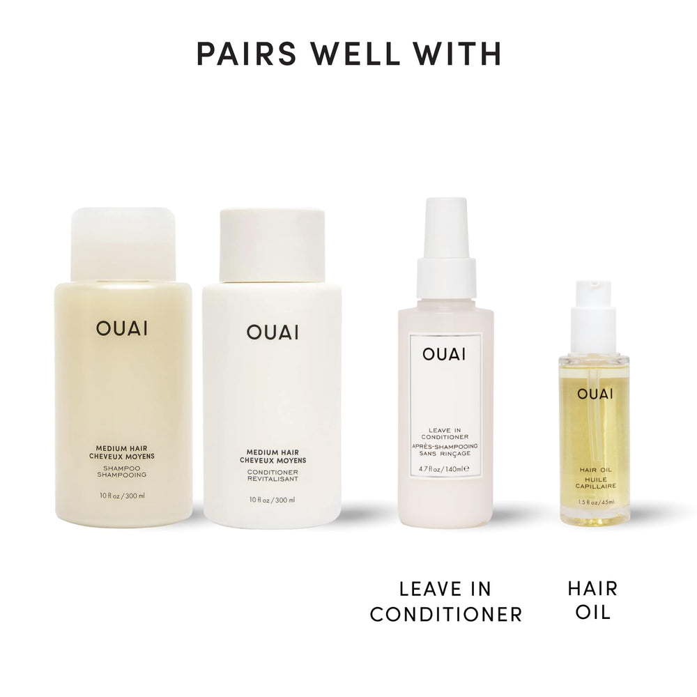 OUAI bottles in hand scale showing 10 fl oz size and travel-friendly benefit