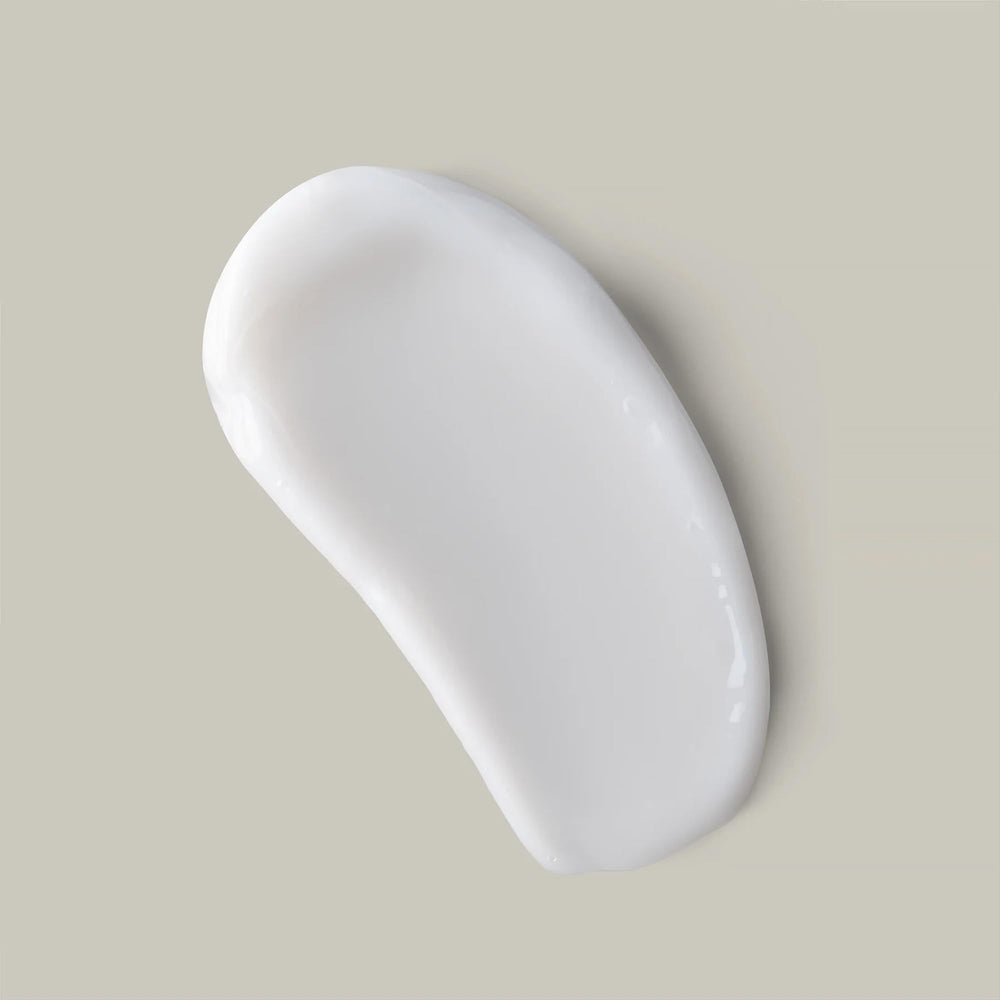 Applying Ouidad curl butter in hand to demonstrate smooth dispersion benefit