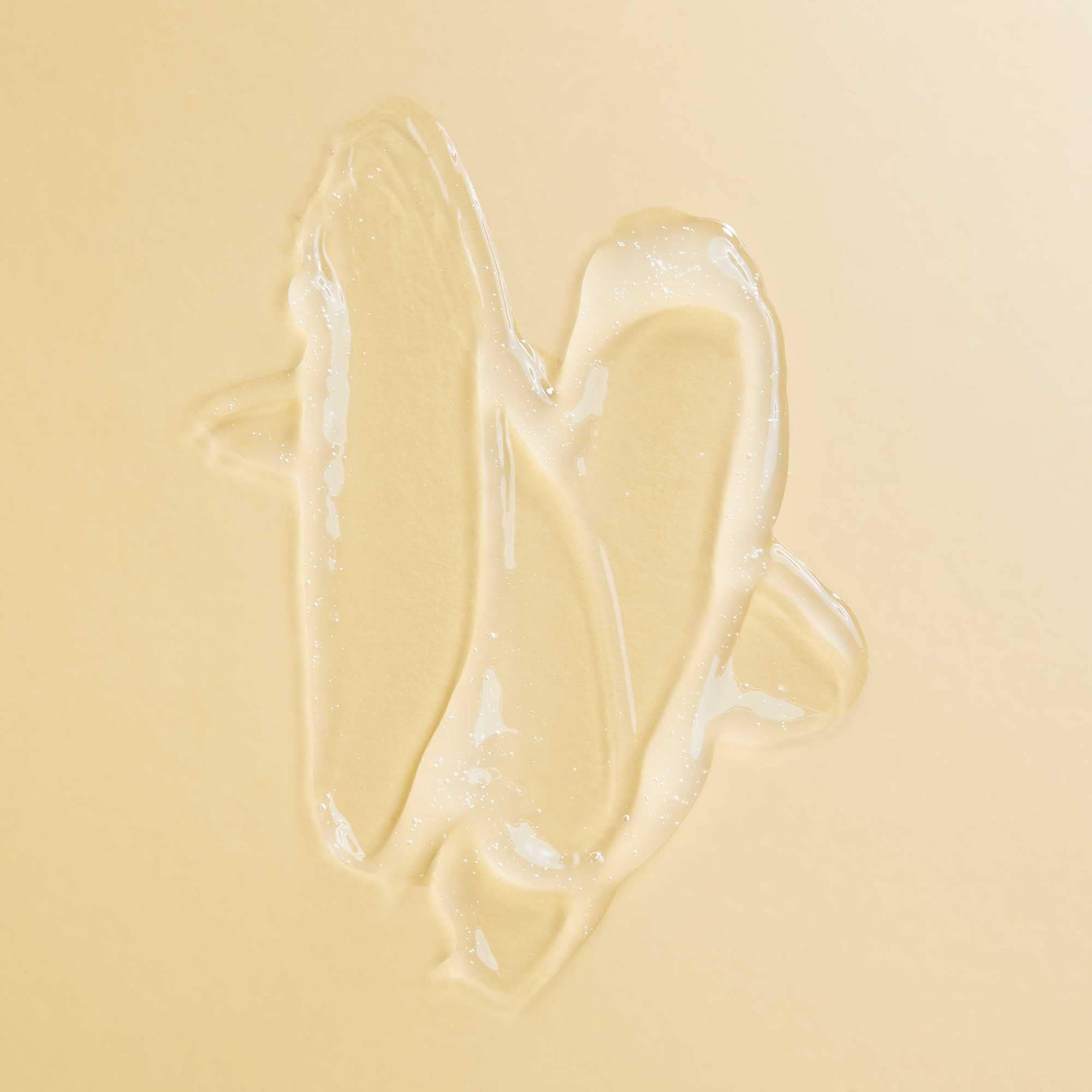 PATTERN applying serum to parting to soothe and hydrate scalp