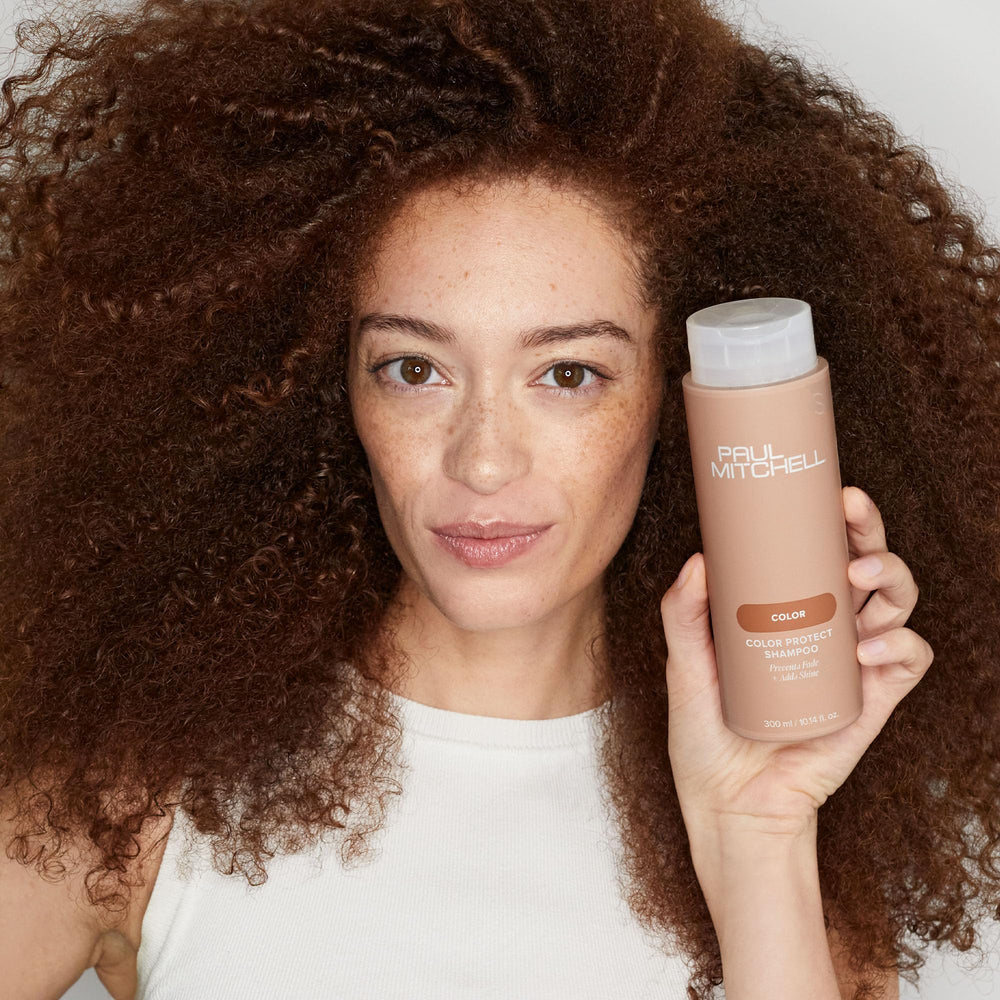 Paul Mitchell shampoo on bathroom shelf styled for vibrant, salon-ready hair