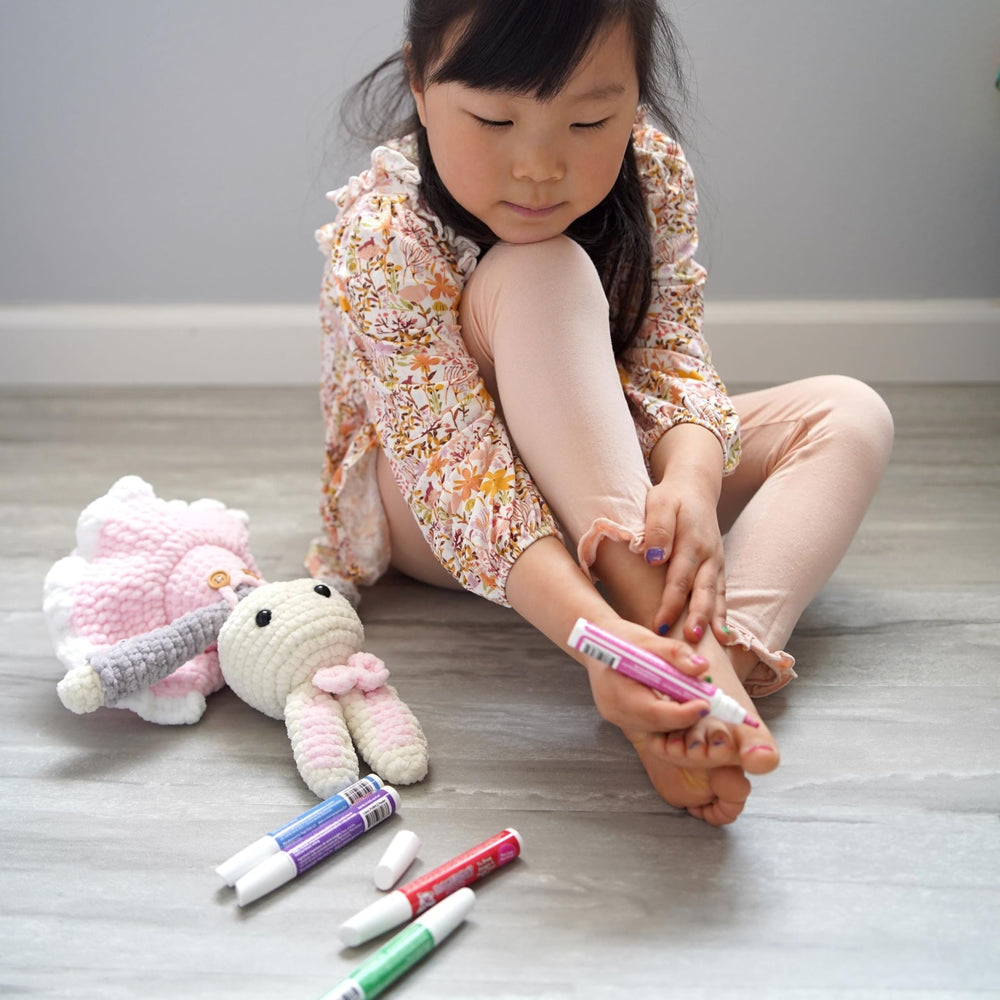 Piggy Paint applying pen on a fingernail demonstrating simple, mess-free use for caregivers