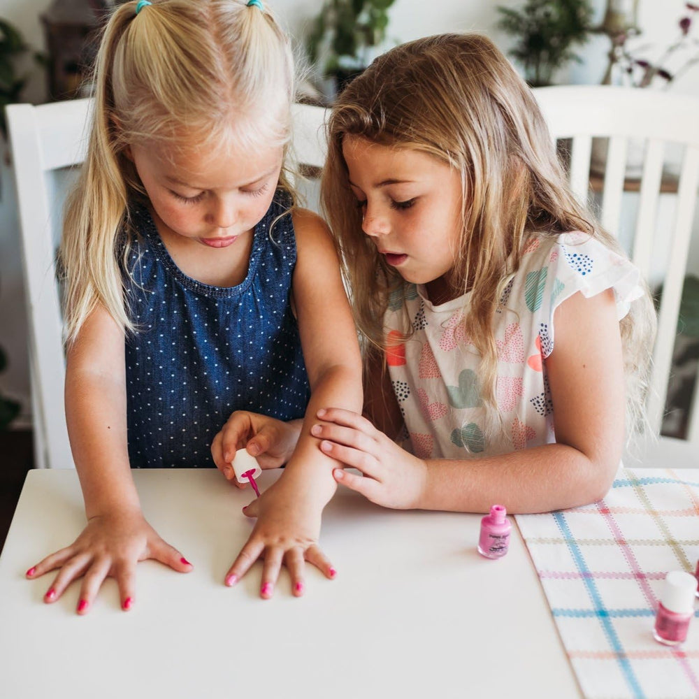 Kids at a small party with Piggy Paint nails, conveying joyful, family-friendly styling
