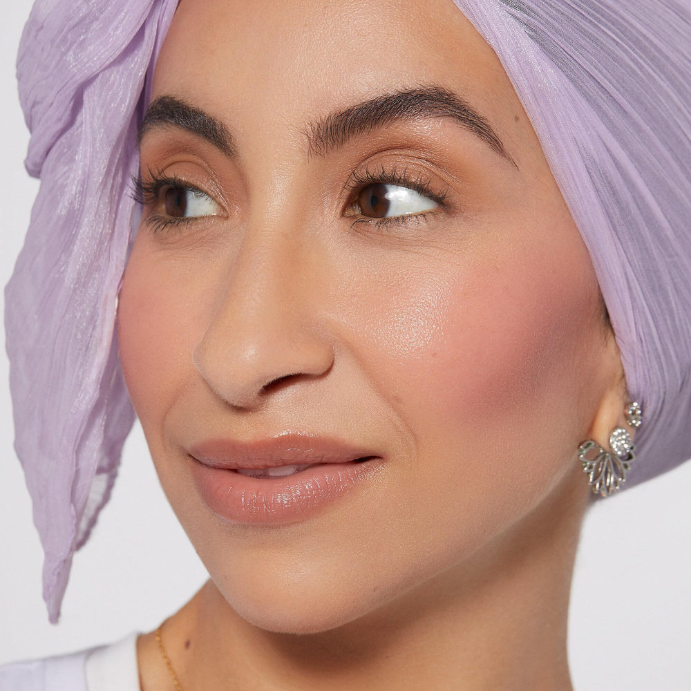 Rare Beauty liquid blush drop on applicator illustrating smooth, blendable consistency