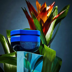 R+Co BLEU ELASTIC jar beside a ruler to show compact 1.7 oz size for travel-friendly convenience