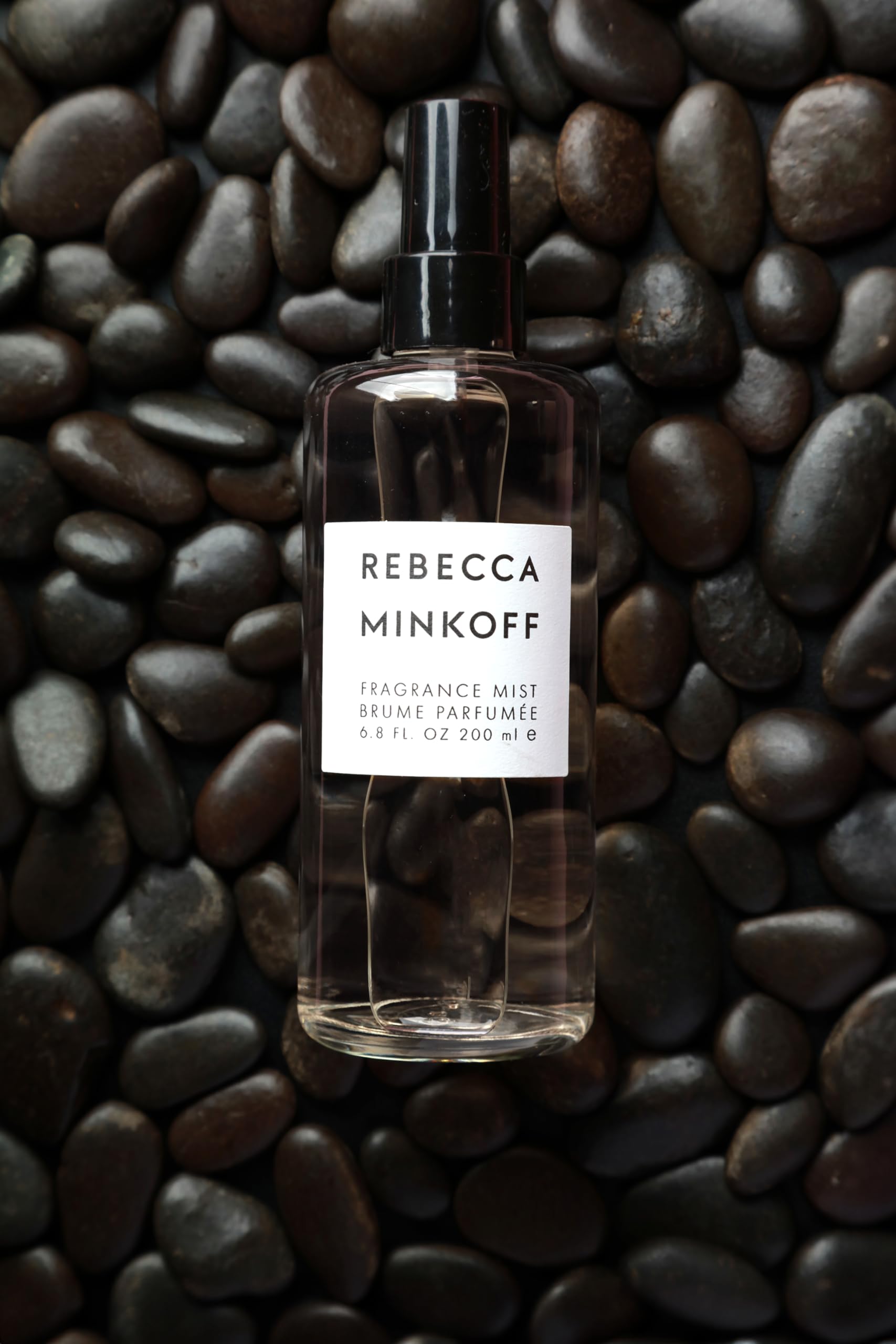 Rebecca Minkoff woman applying mist outdoors for daytime freshness and confident impression