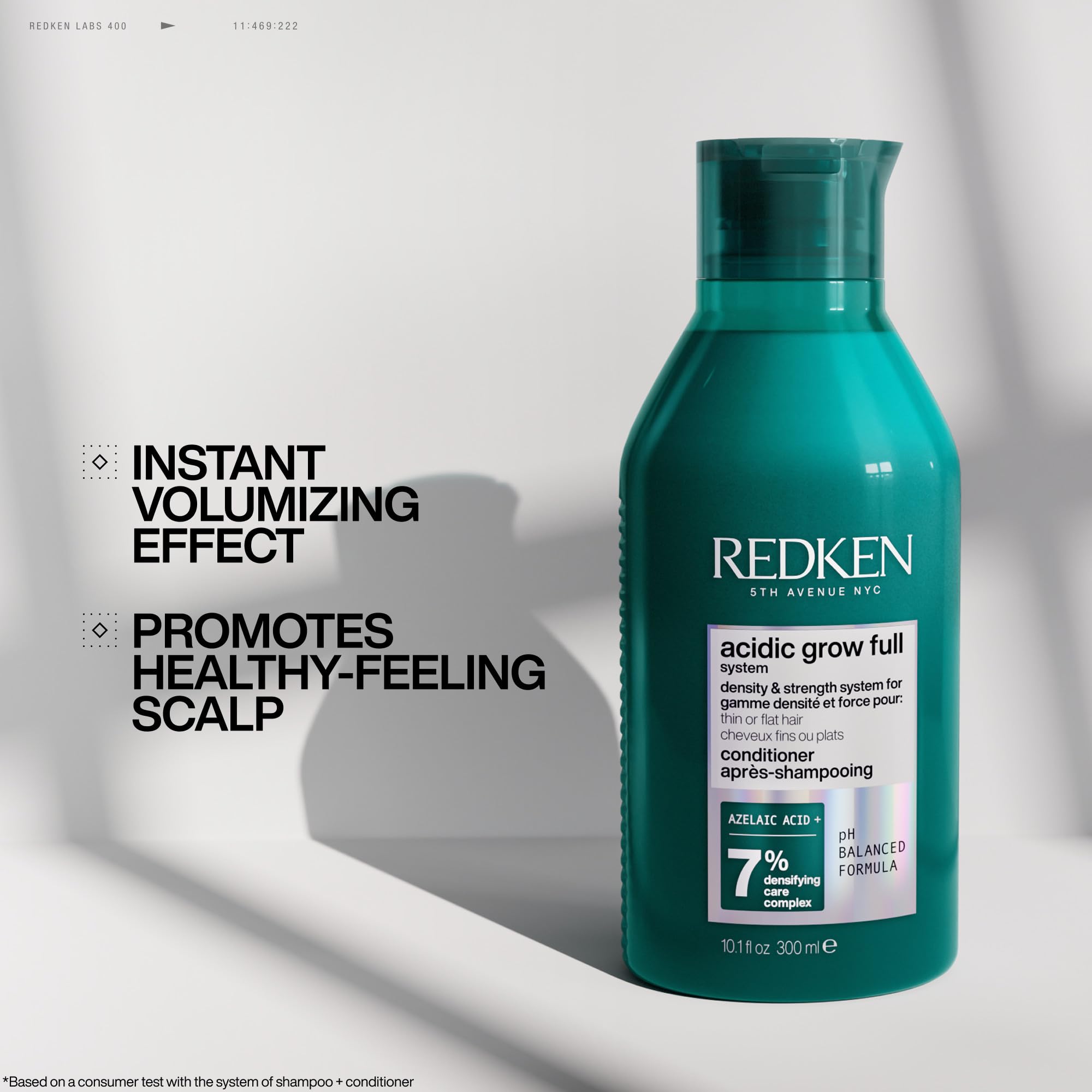 Redken acidic grow held in hand to show bottle size and travel-friendly scale