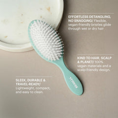 Remilia Hair brush held in hand illustrating compact size and travel convenience