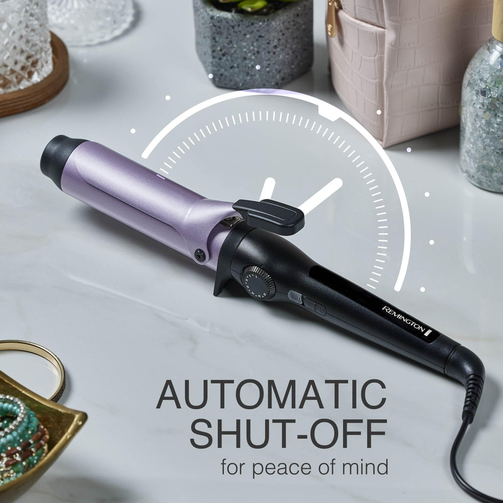 Remington curling iron held in hand beside hair strand to show size and scale
