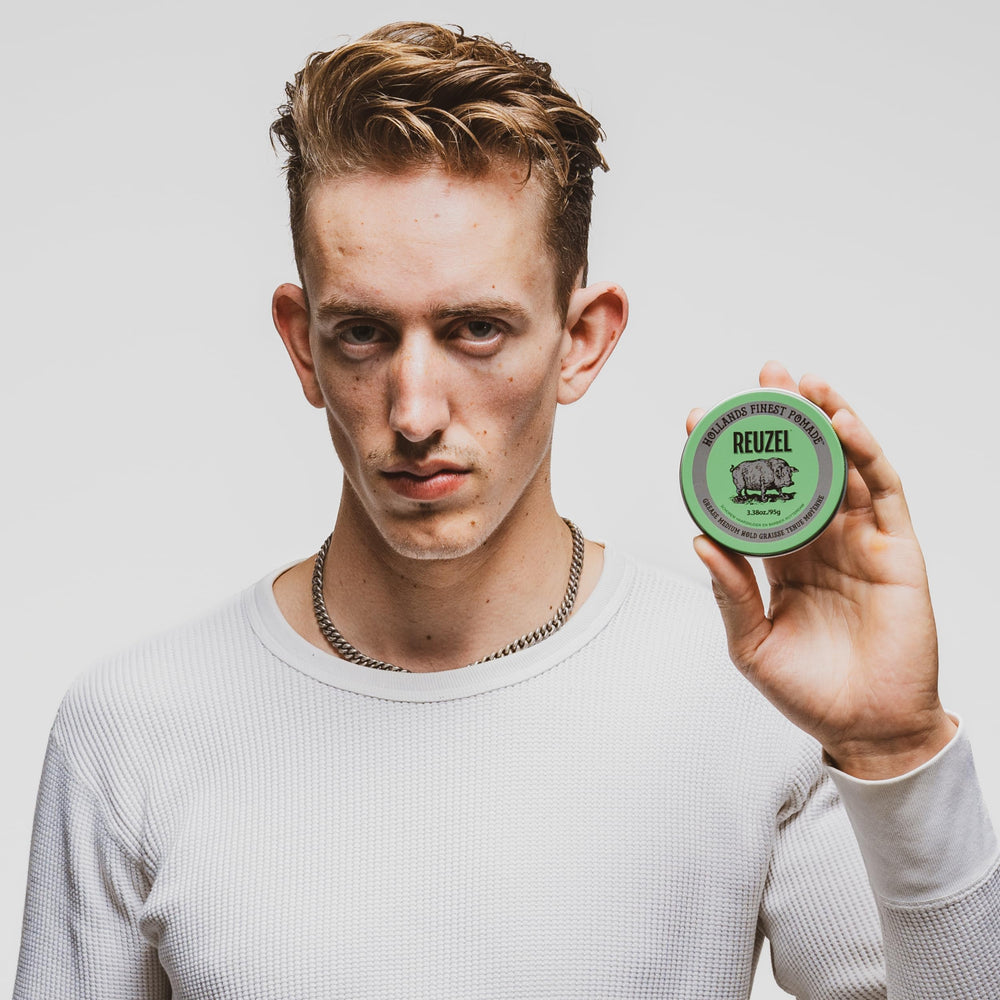 REUZEL in a barbershop setting on counter, evokes professional styling results