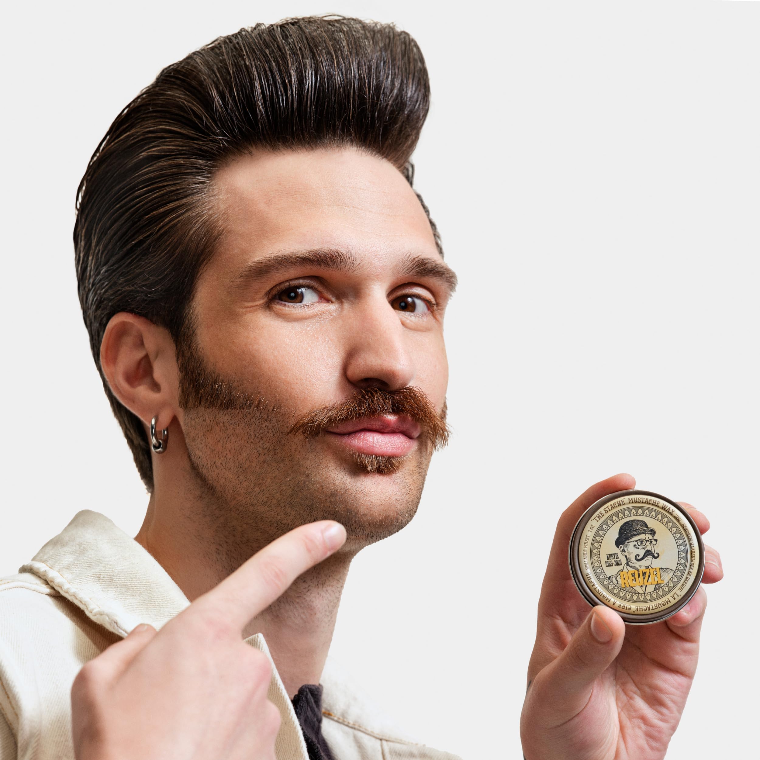 REUZEL mustache wax placed on bathroom shelf in grooming scene showing daily use benefit