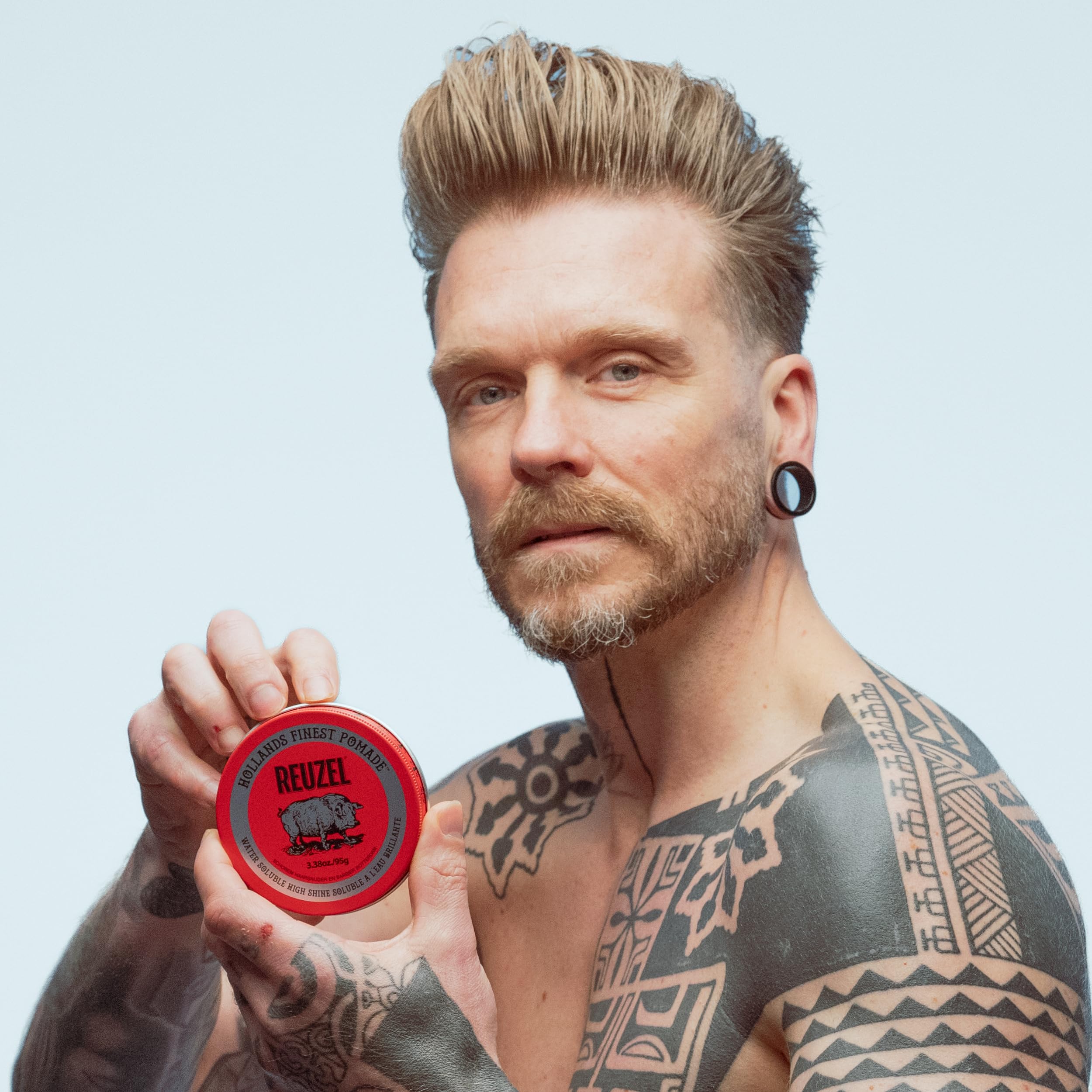 REUZEL Red pomade being rubbed between fingers for effortless application