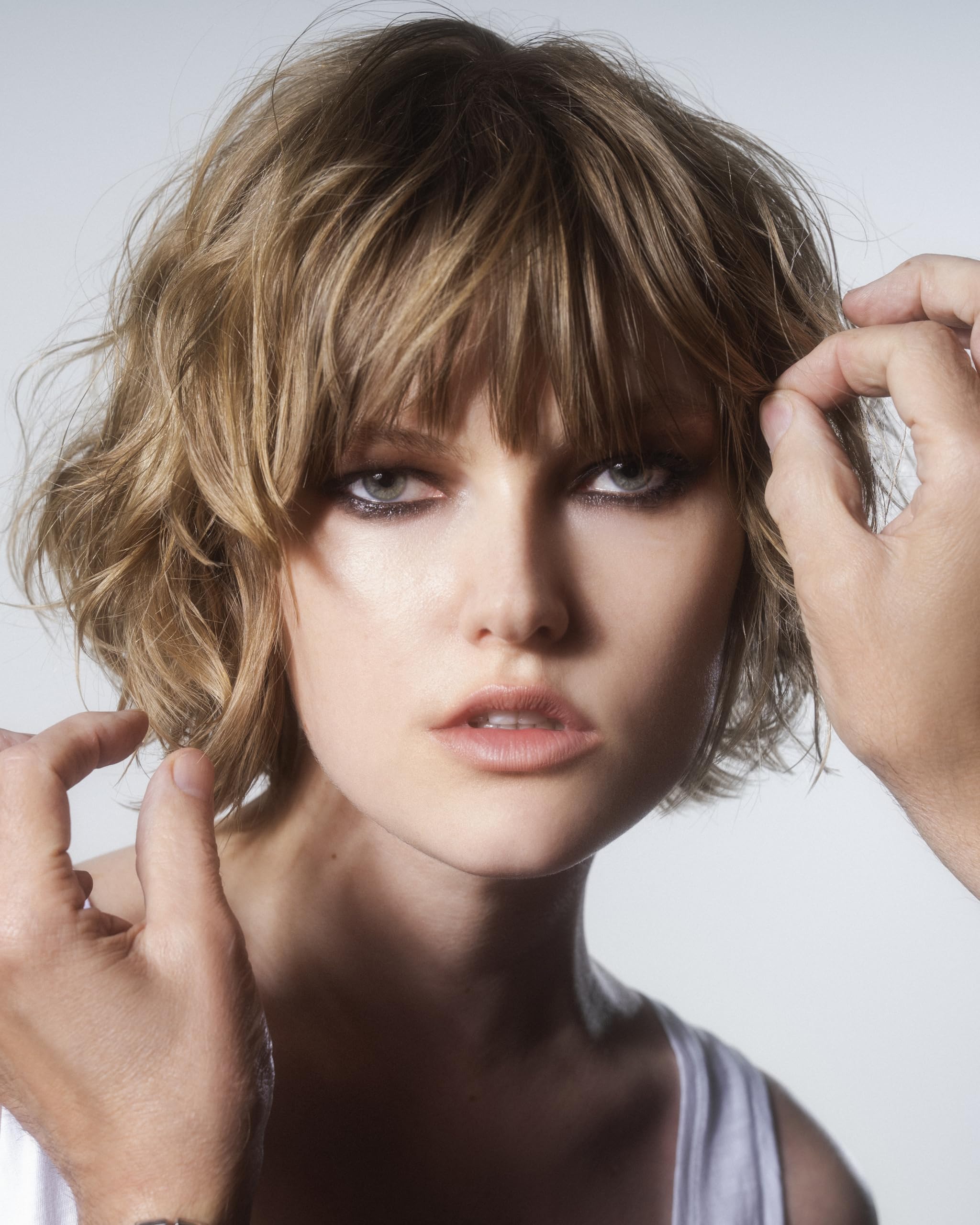 R+Co spraying on hair in salon to show styling protection and shine