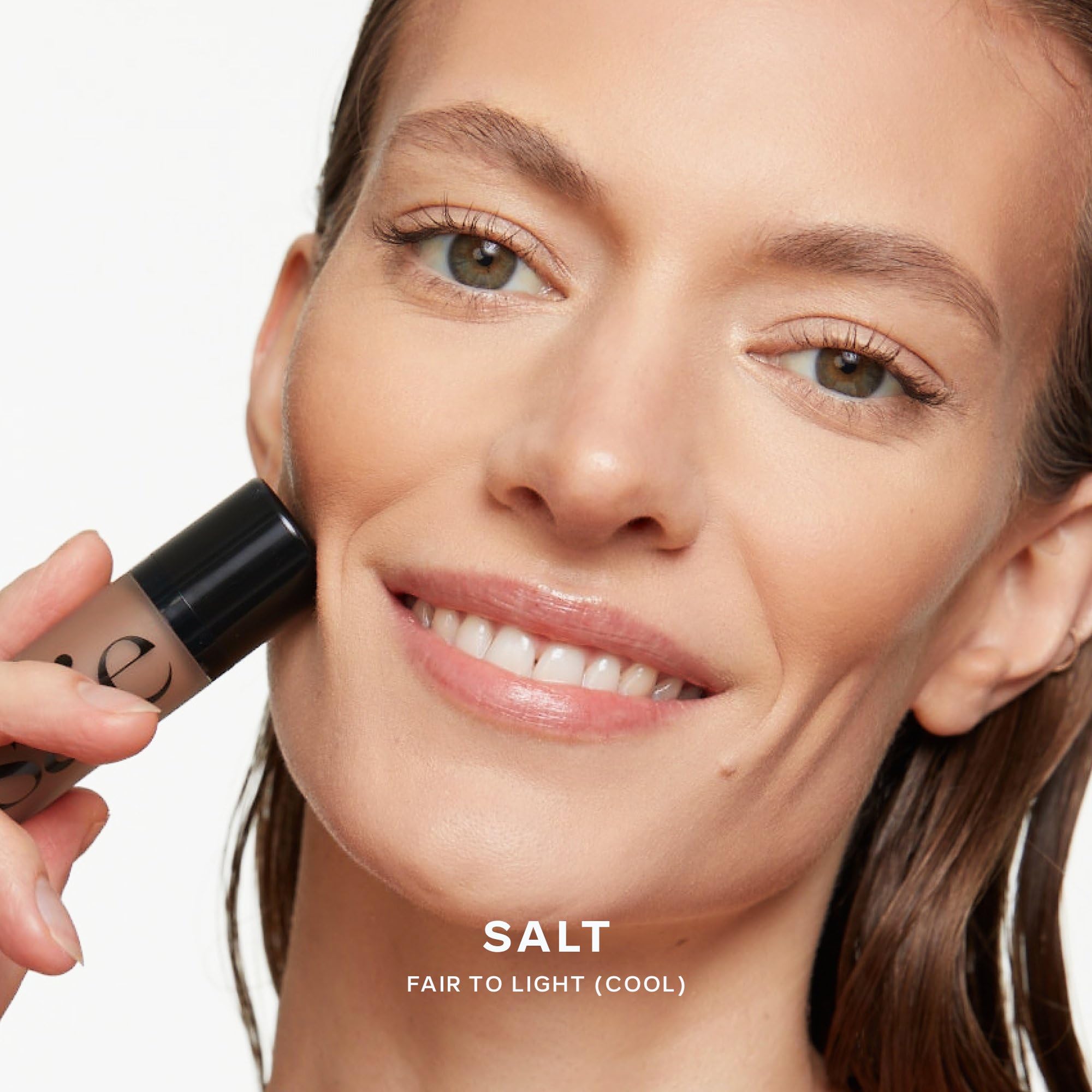 Saie model applying Dew Bronze on cheekbones for instant sun-kissed glow
