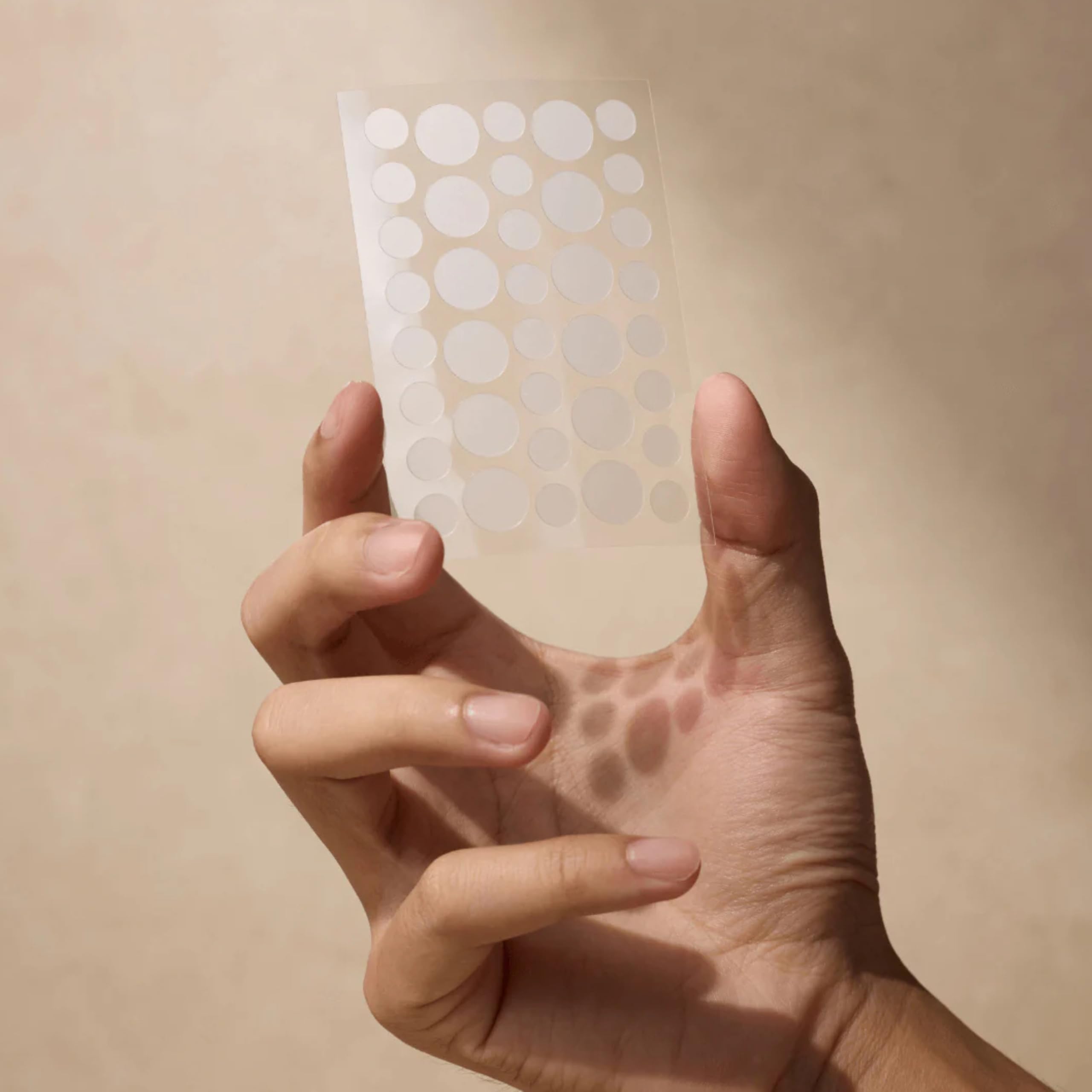 Shield patch applied to skin visibly flat and protecting a blemish