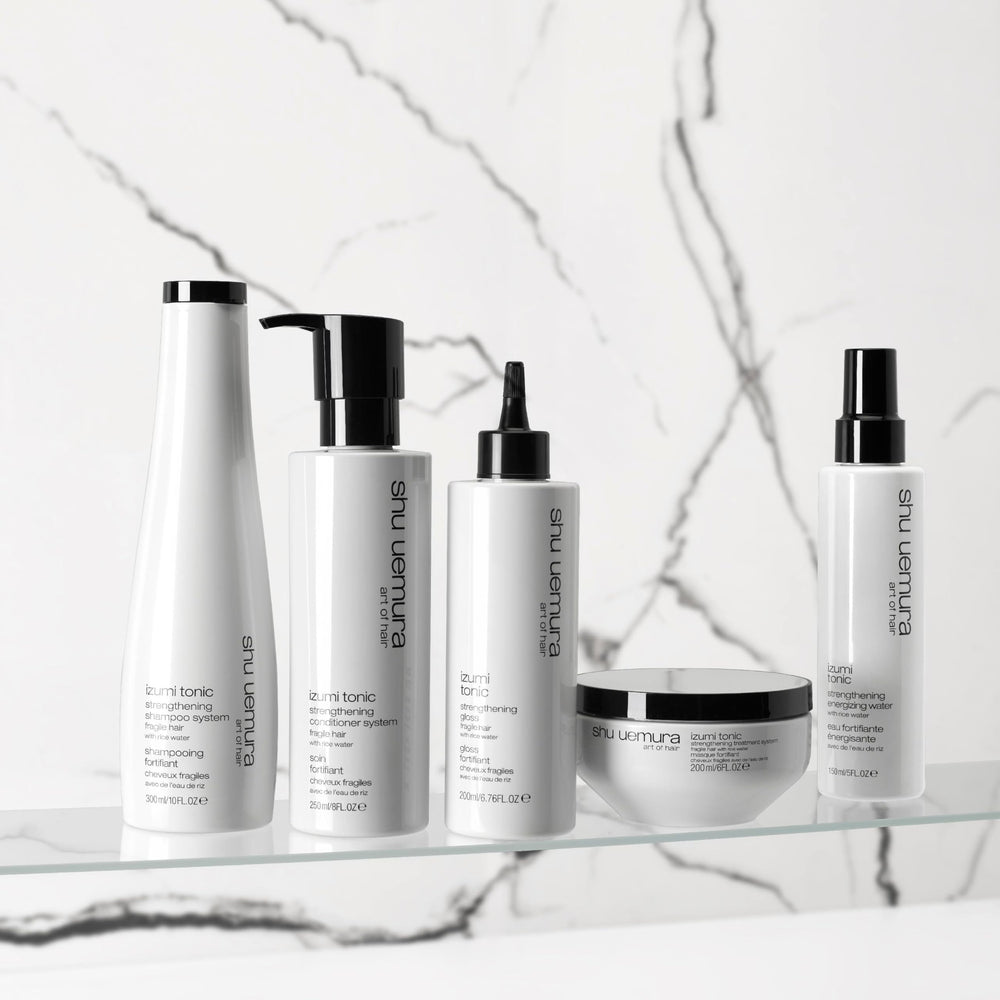 shu uemura art of hair bottle on bathroom counter with plants, suggesting daily routine and polished shine