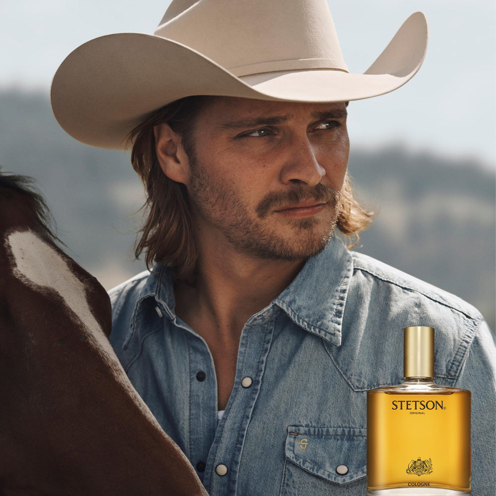 Man outdoors wearing Stetson conveying rugged, timeless masculine scent