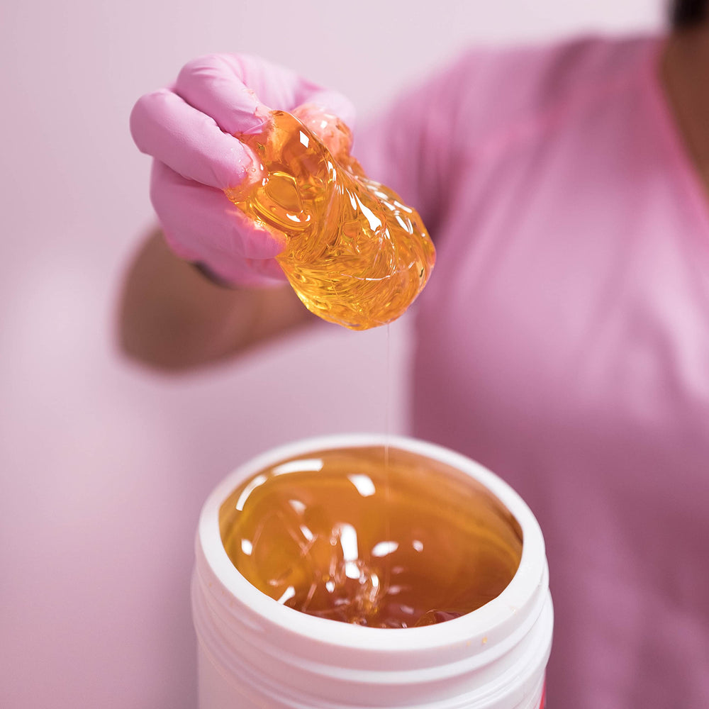 Melted Sugaring NYC paste on spoon demonstrating spreadable consistency for application