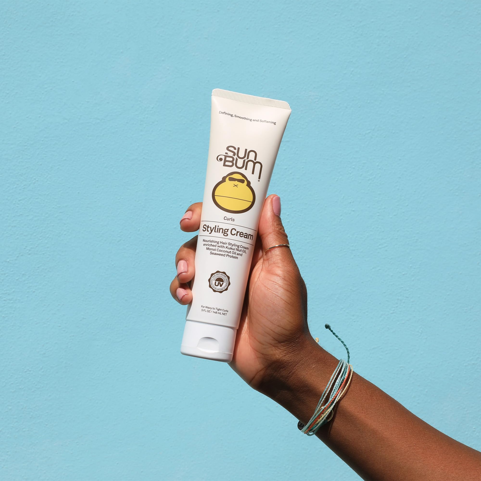Sun Bum being scrunched into curls by hands to create defined, touchable waves