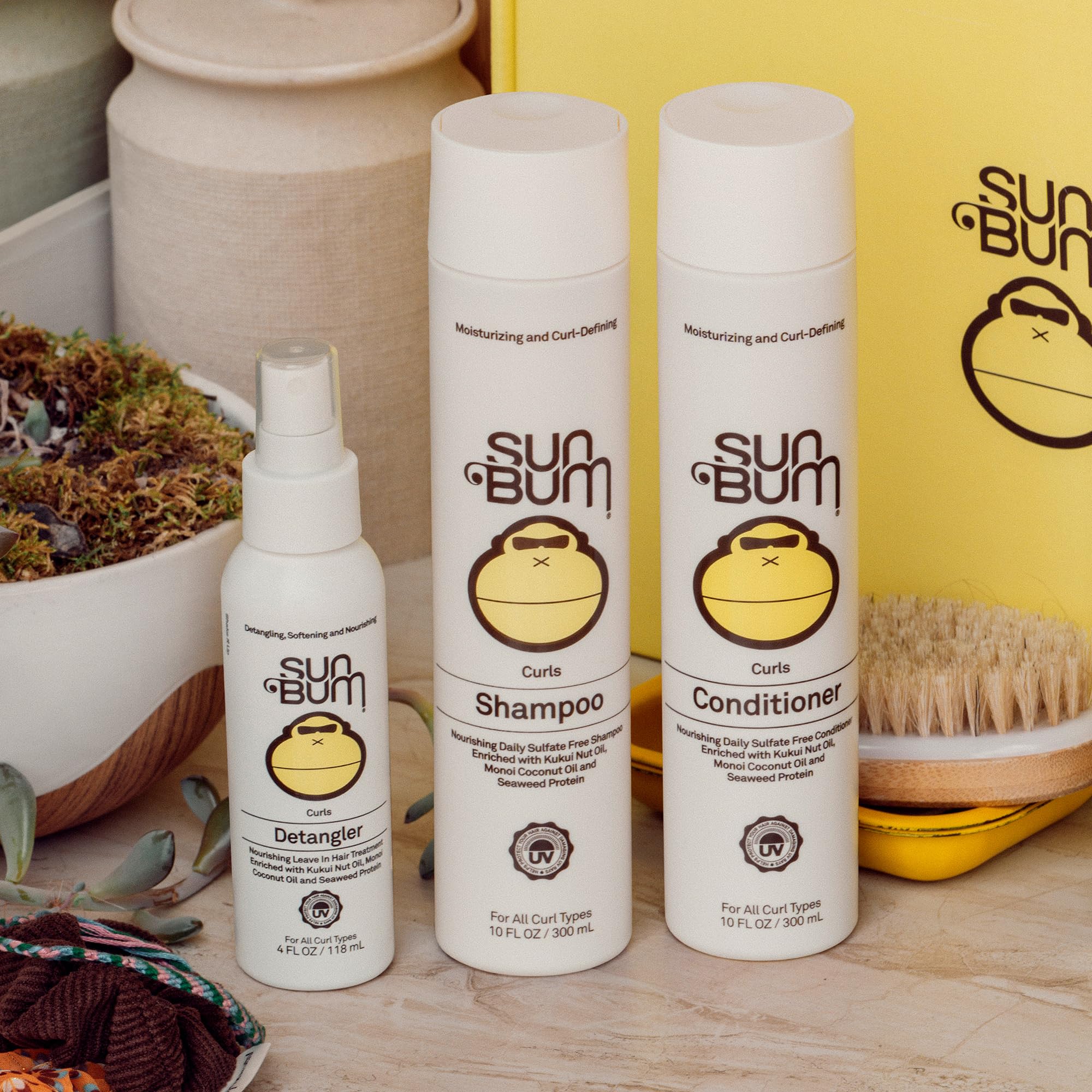 Sun Bum 4 oz detangler beside everyday items for size comparison