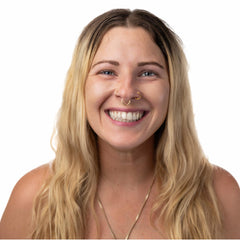 Applying Sun Zapper stick to face for targeted sun protection while surfing