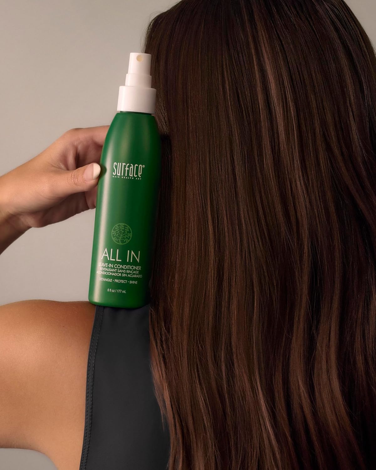 Model with curly hair using Surface spray for reduced frizz and enhanced definition
