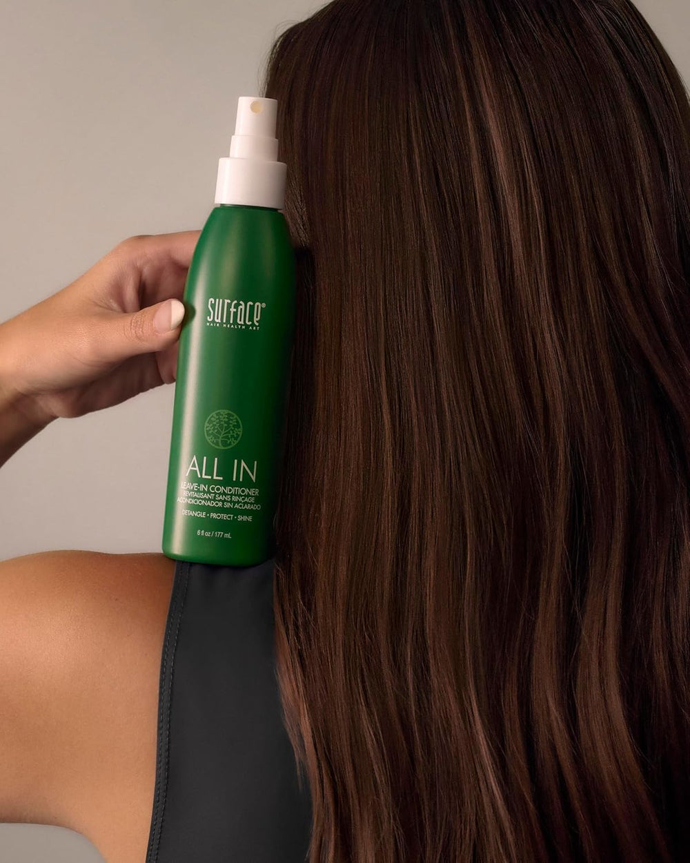 Model with curly hair using Surface spray for reduced frizz and enhanced definition