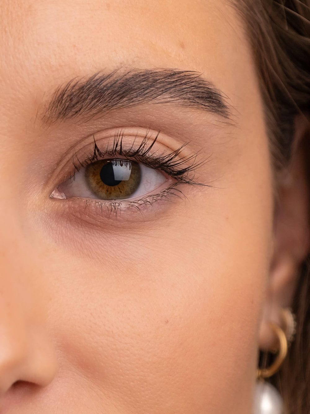 Sweed Lashes clear serum drop on fingertip showing lightweight texture and quick absorption benefit