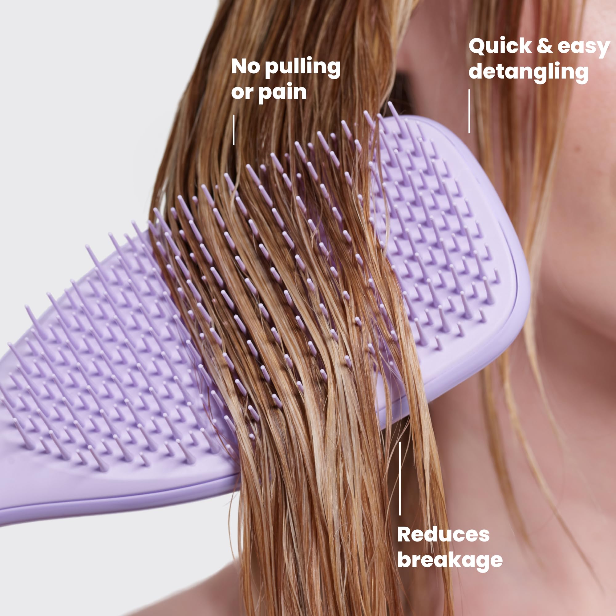 TANGLE TEEZER held in hand to show scale and easy travel-friendly use