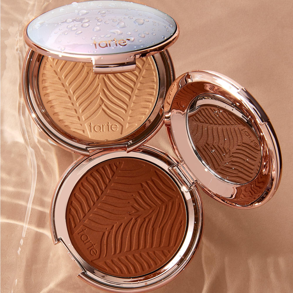 tarte compact beside hand to show size and portable, purse-friendly benefit