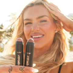 tarte applying stick bronzer in hand demonstrating quick on-the-go sculpting benefit