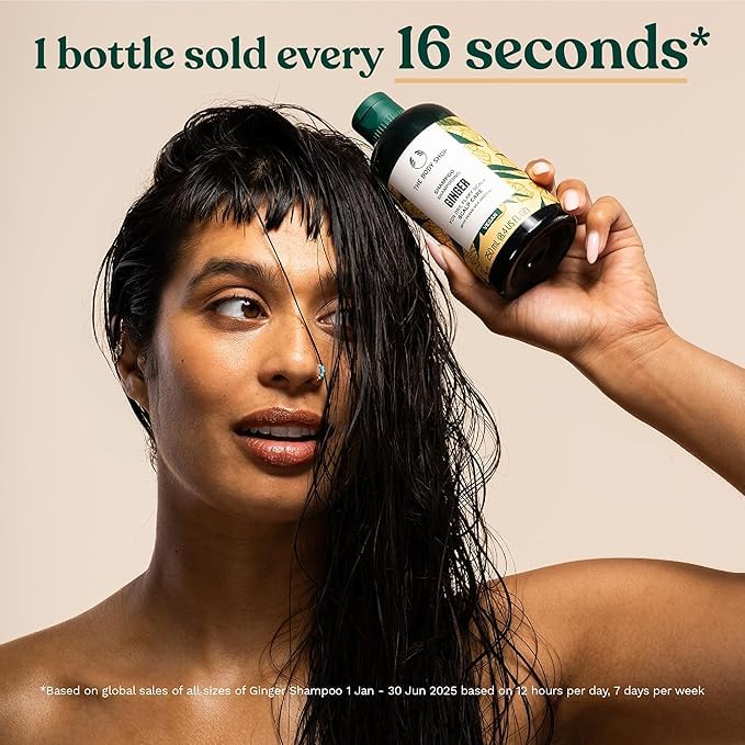 The Body Shop ginger shampoo next to everyday items showing 13.5 fl oz scale benefit