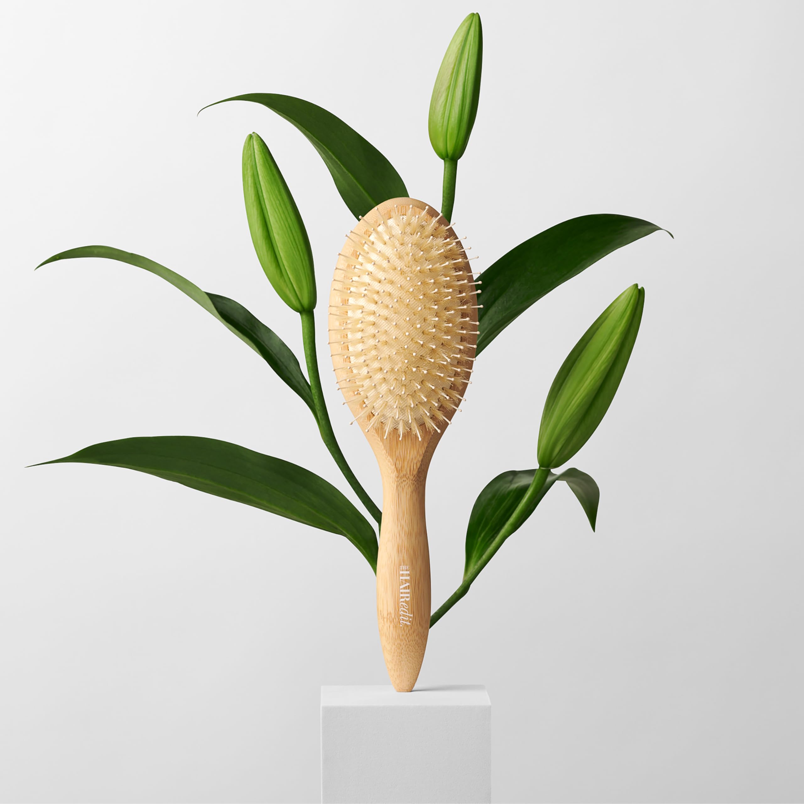 The Hair Edit brush held in hand to show scale and easy maneuverability benefit