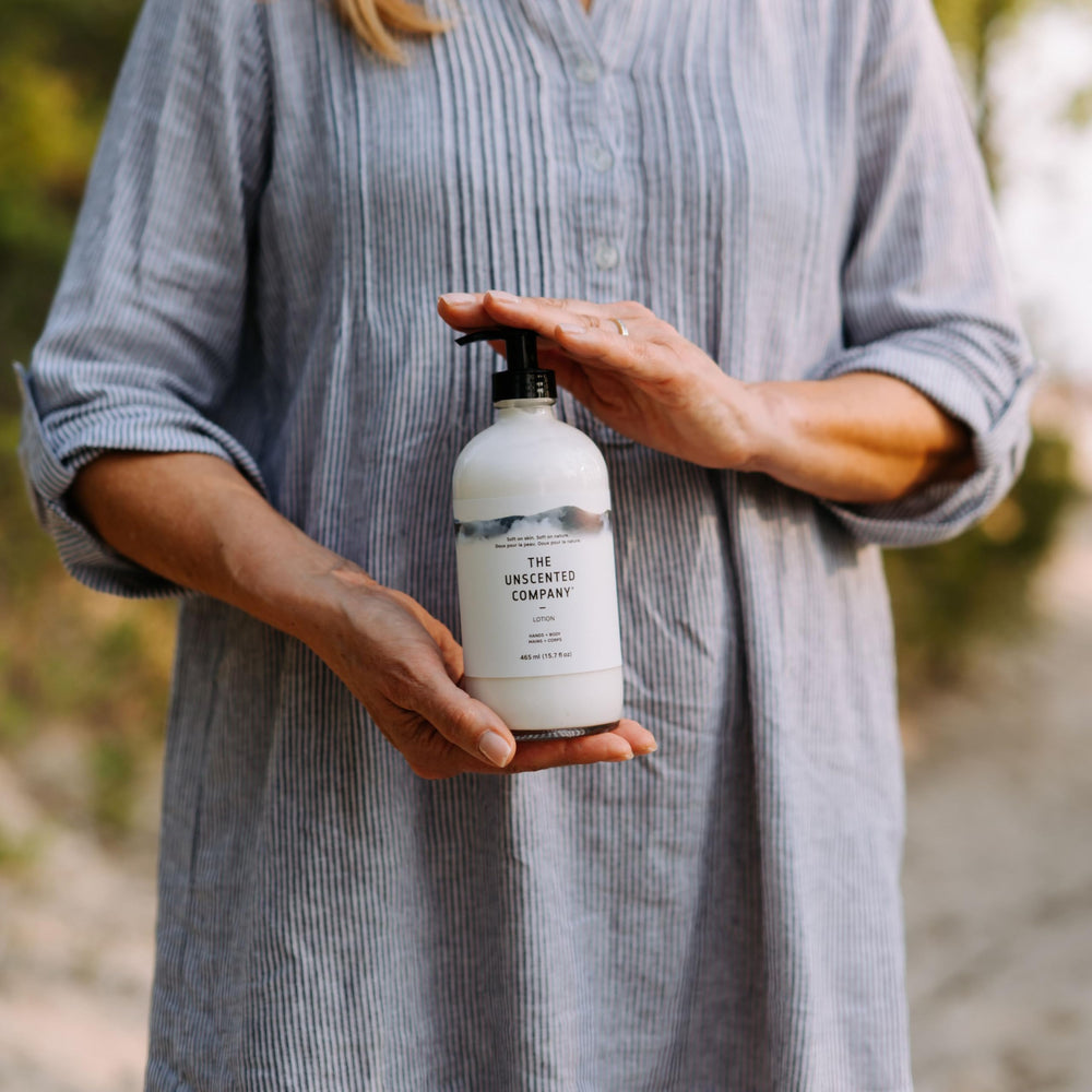 The Unscented Company bottle held in hand indicating travel-friendly size