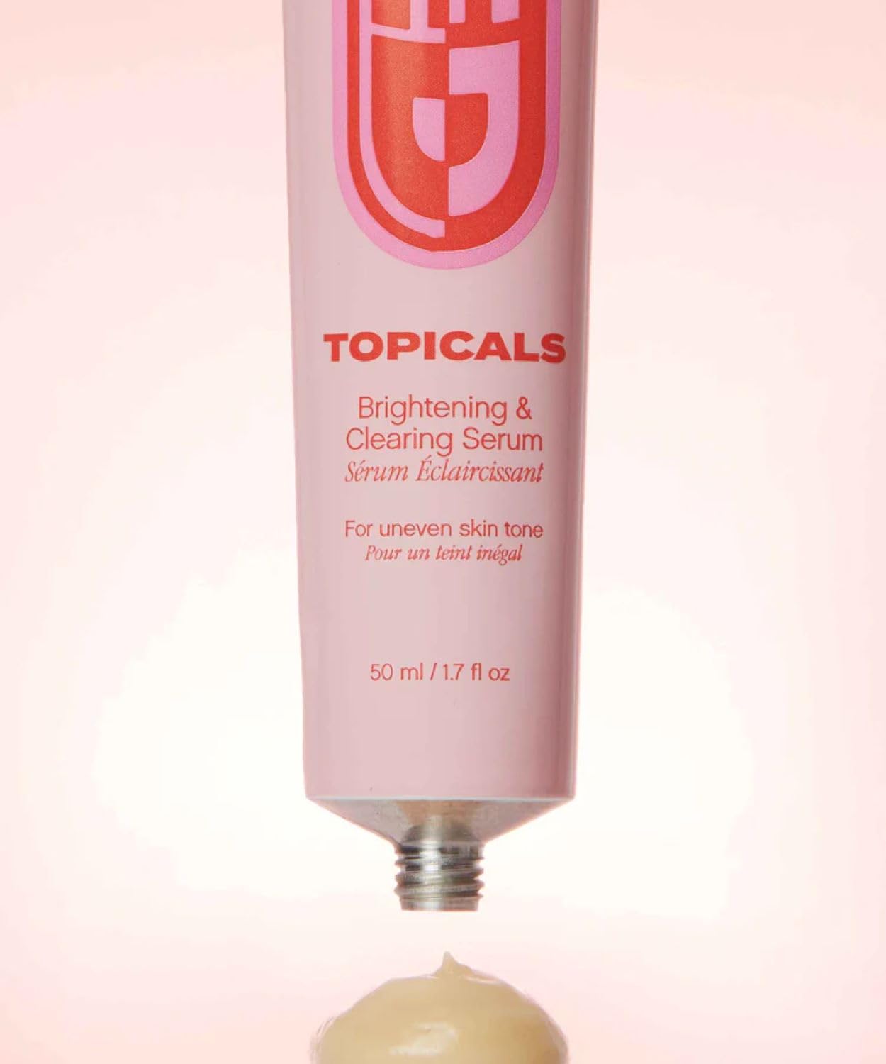 Topicals bottle next to coin to show 1.7 fl oz scale and portable size benefit