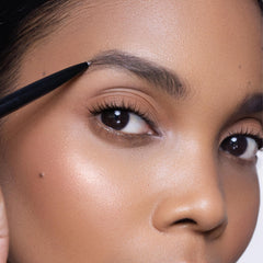 Trish McEvoy precision brow shaper next to a coin showing compact size and portability benefit