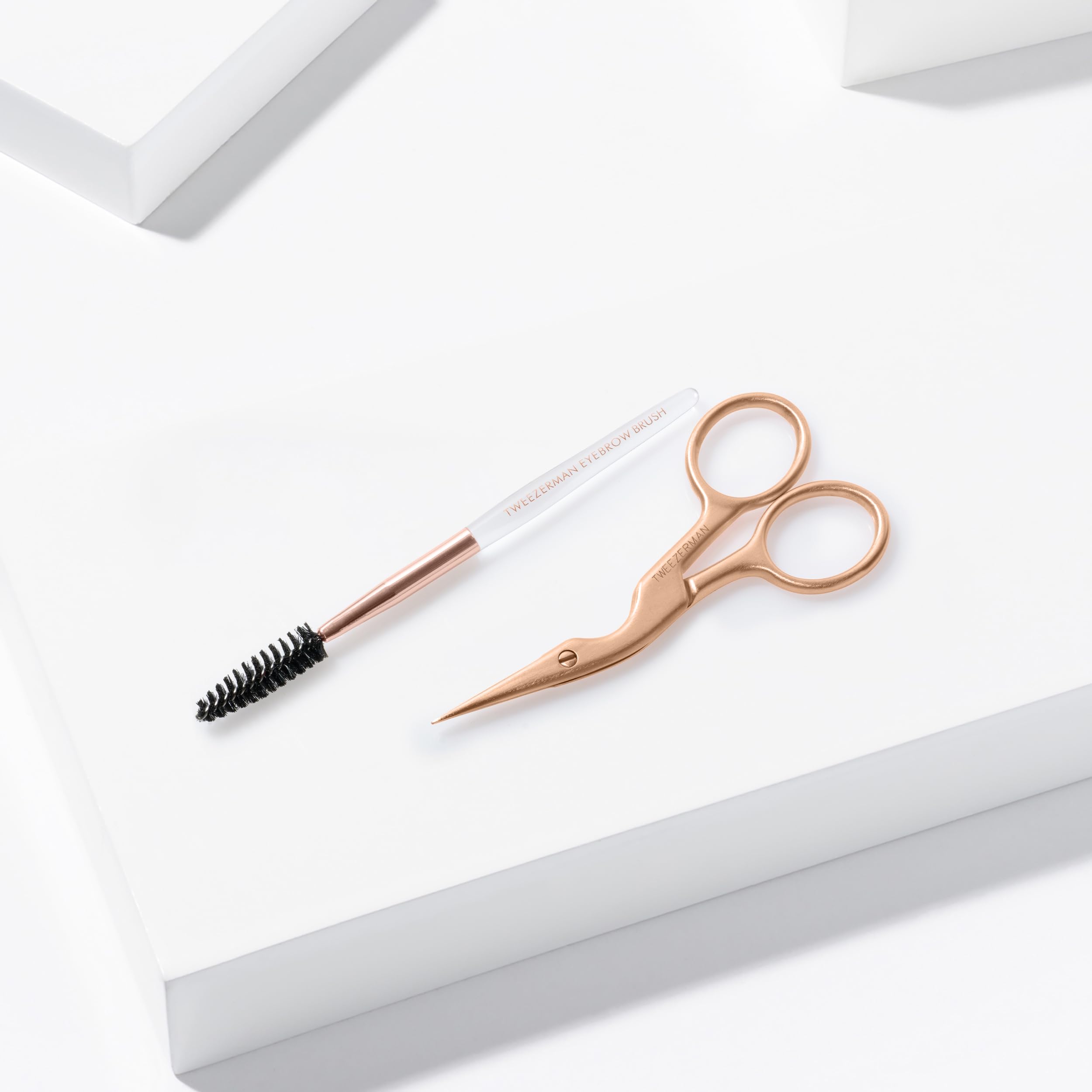 Tweezerman brush styling brows to blend trimmed hairs for a natural finish