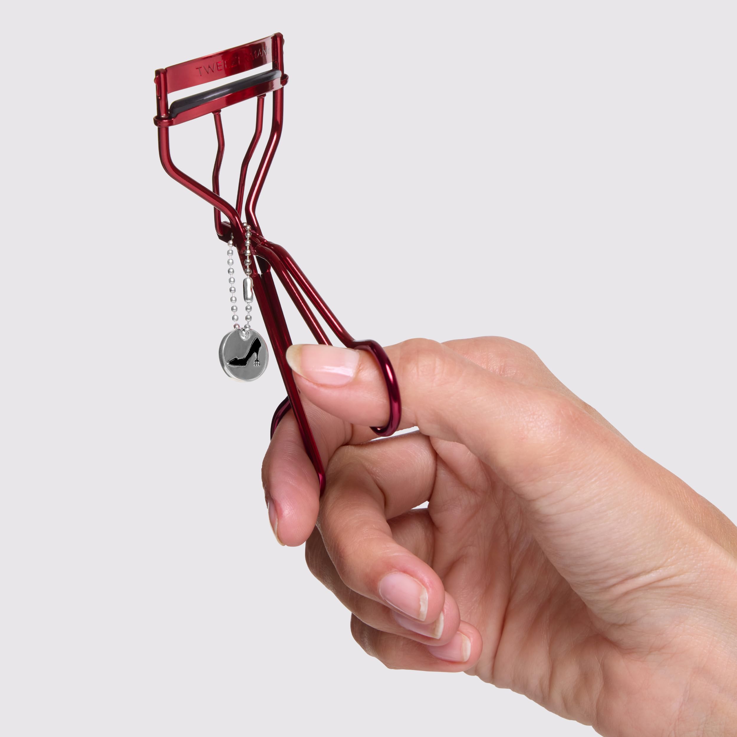 Tweezerman curler held in hand demonstrating use benefit: easy, safe curling
