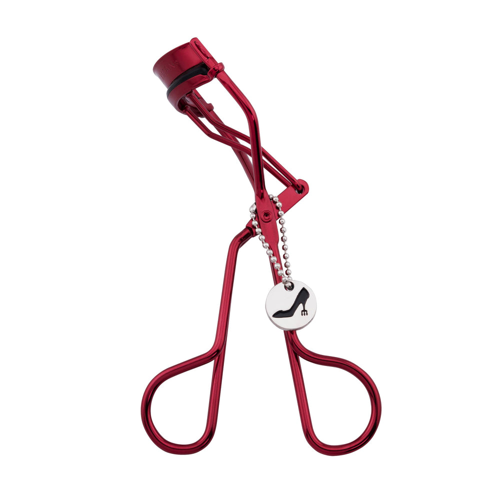 Tweezerman curler beside ruler showing dimensions benefit: compact travel friendly