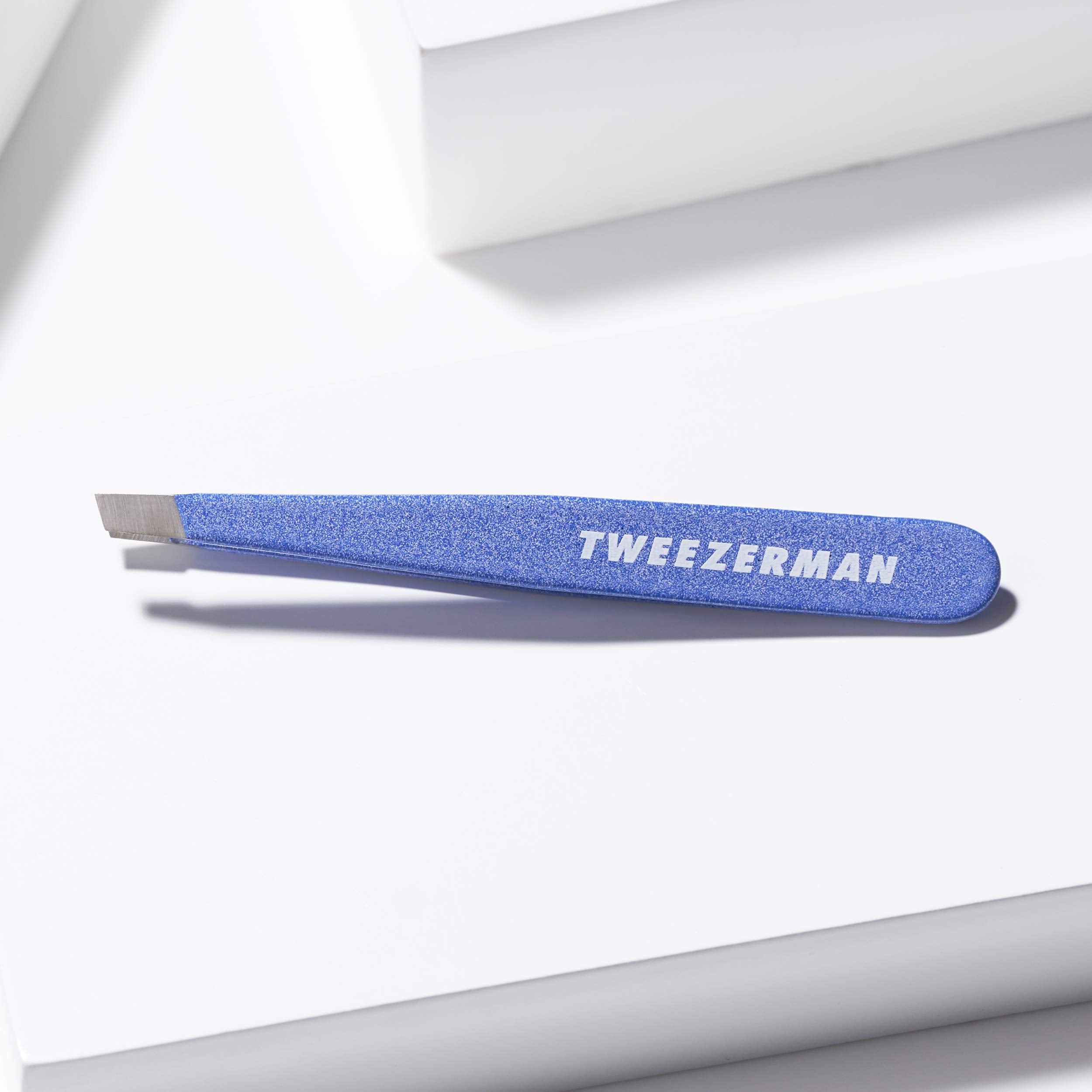 Tweezerman Mini Slant held in hand demonstrating size and comfortable control