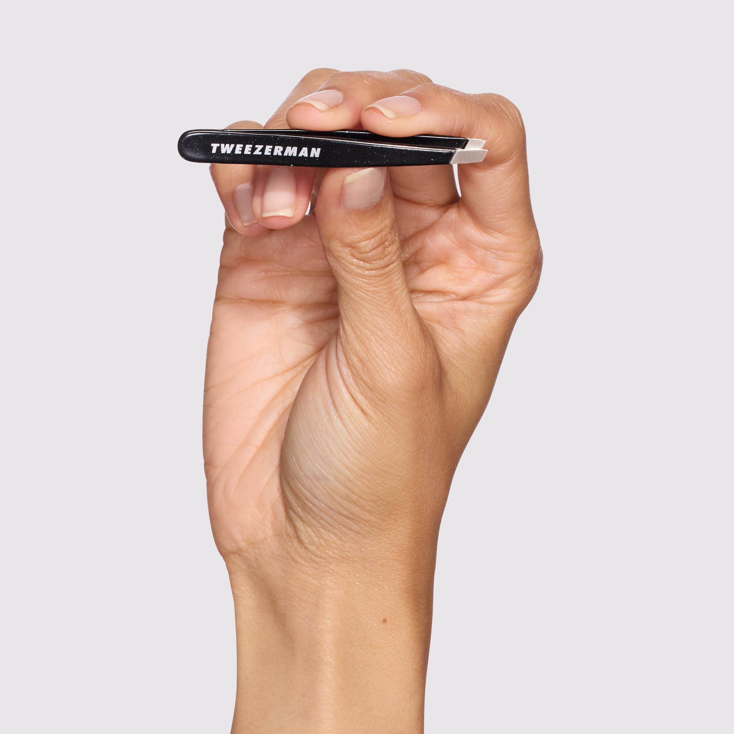 Tweezerman tweezer in use removing a brow hair for clean shaping benefit