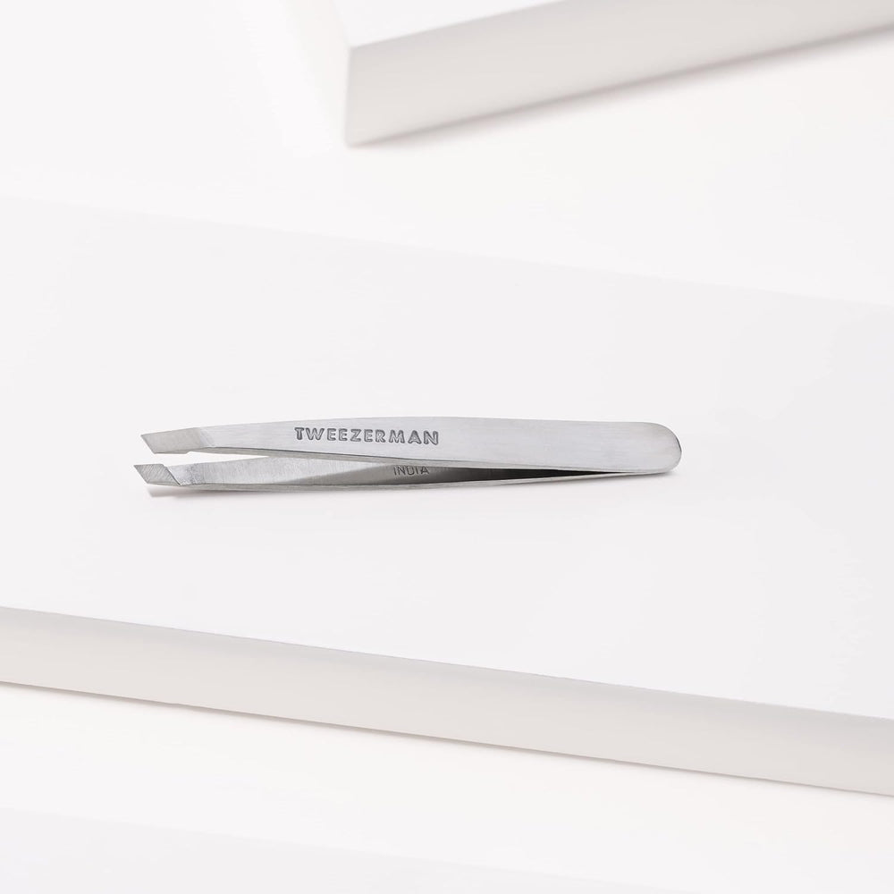 Tweezerman tweezer removing a fine eyebrow hair for clean shaping result