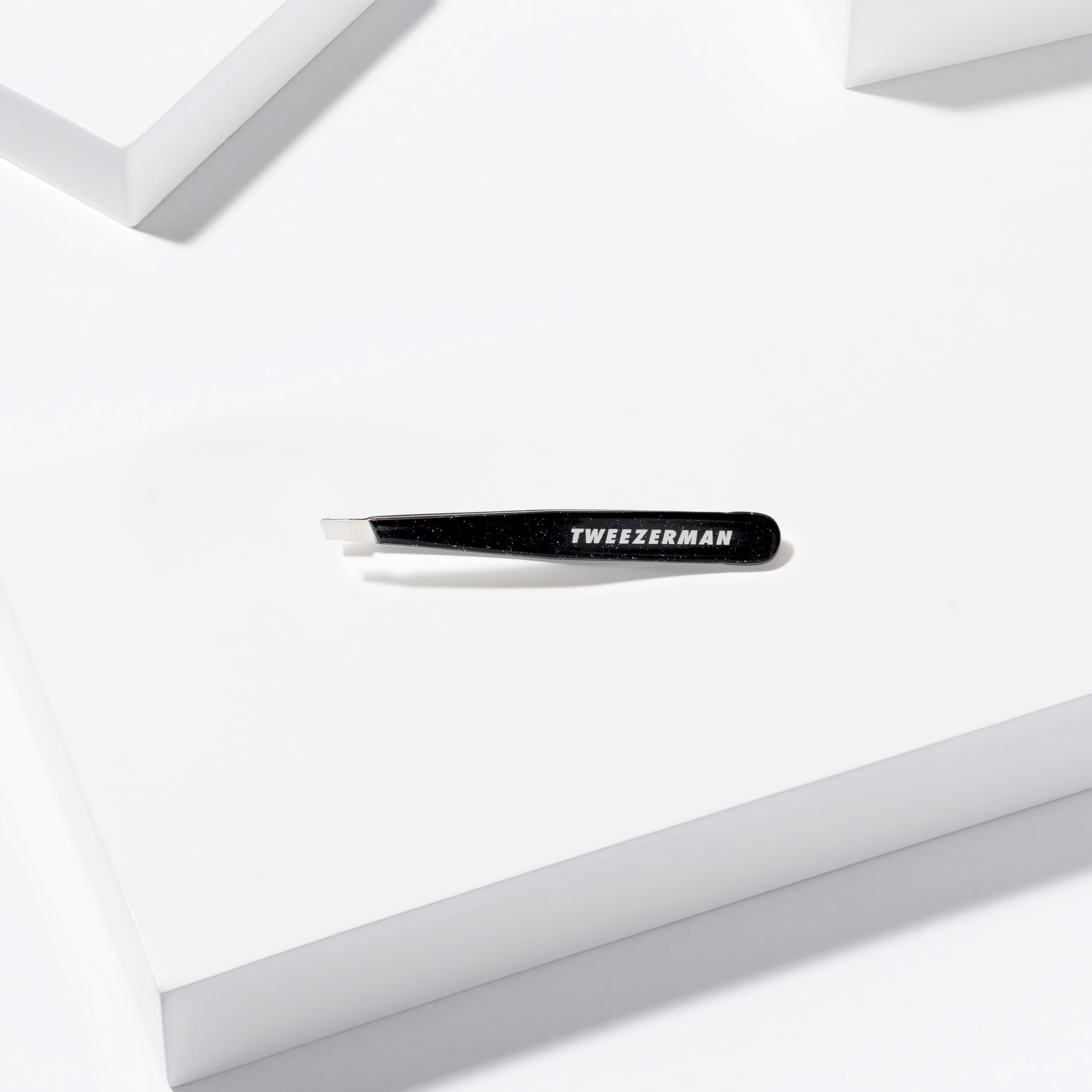 Tweezerman mini beside full-size showing travel-friendly compact comparison