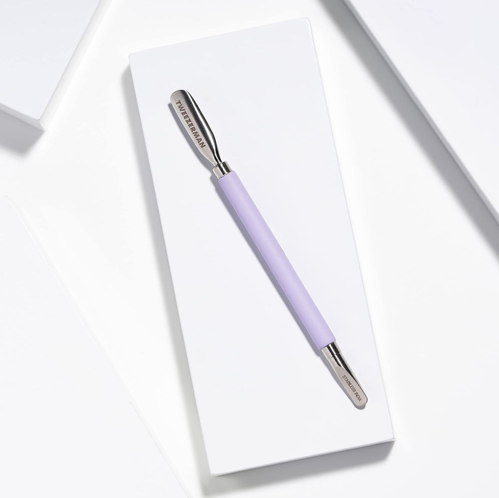 Tweezerman Pushy in use during at-home manicure for neat nail beds