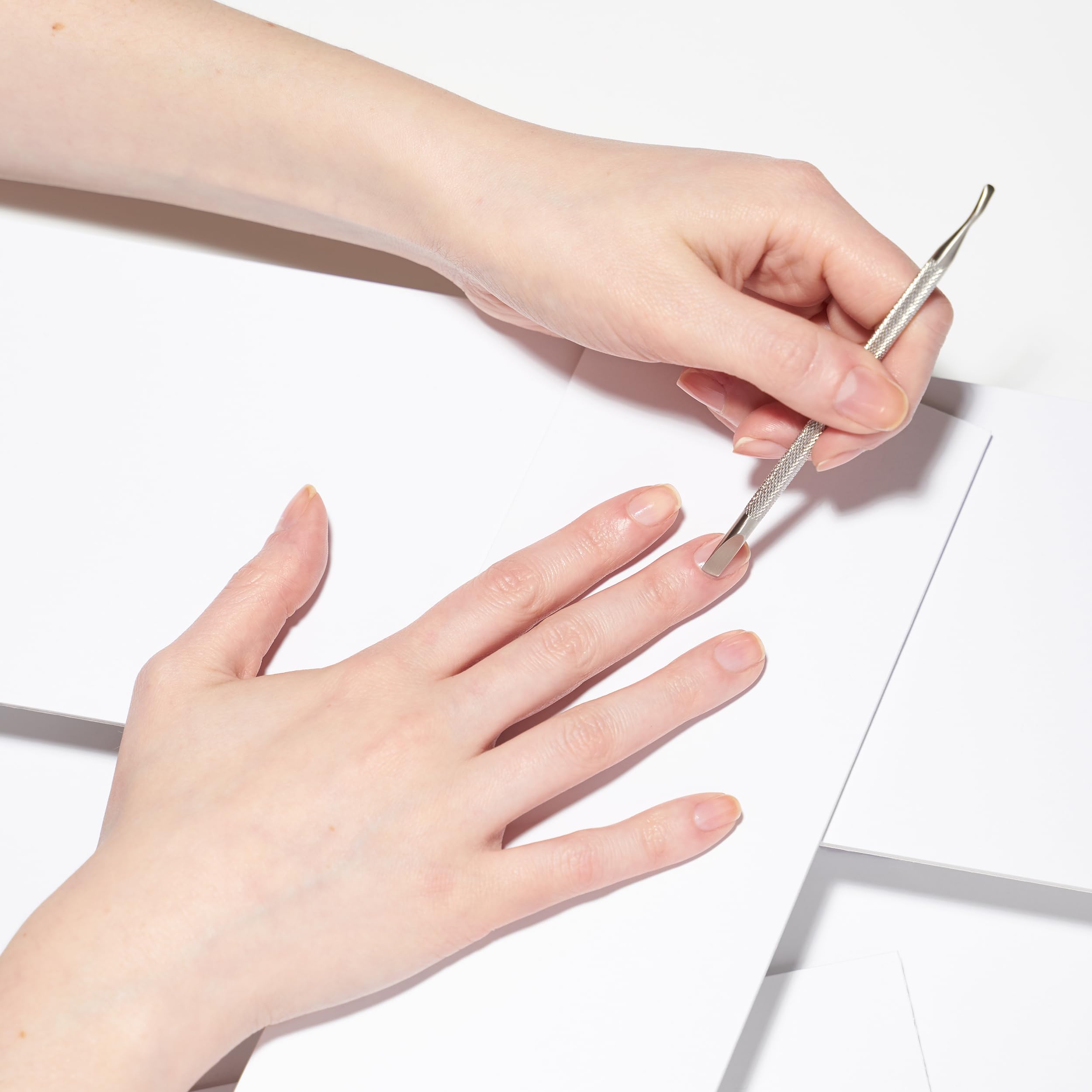 Tweezerman Pushy in a home manicure scene demonstrating convenient two‑in‑one use