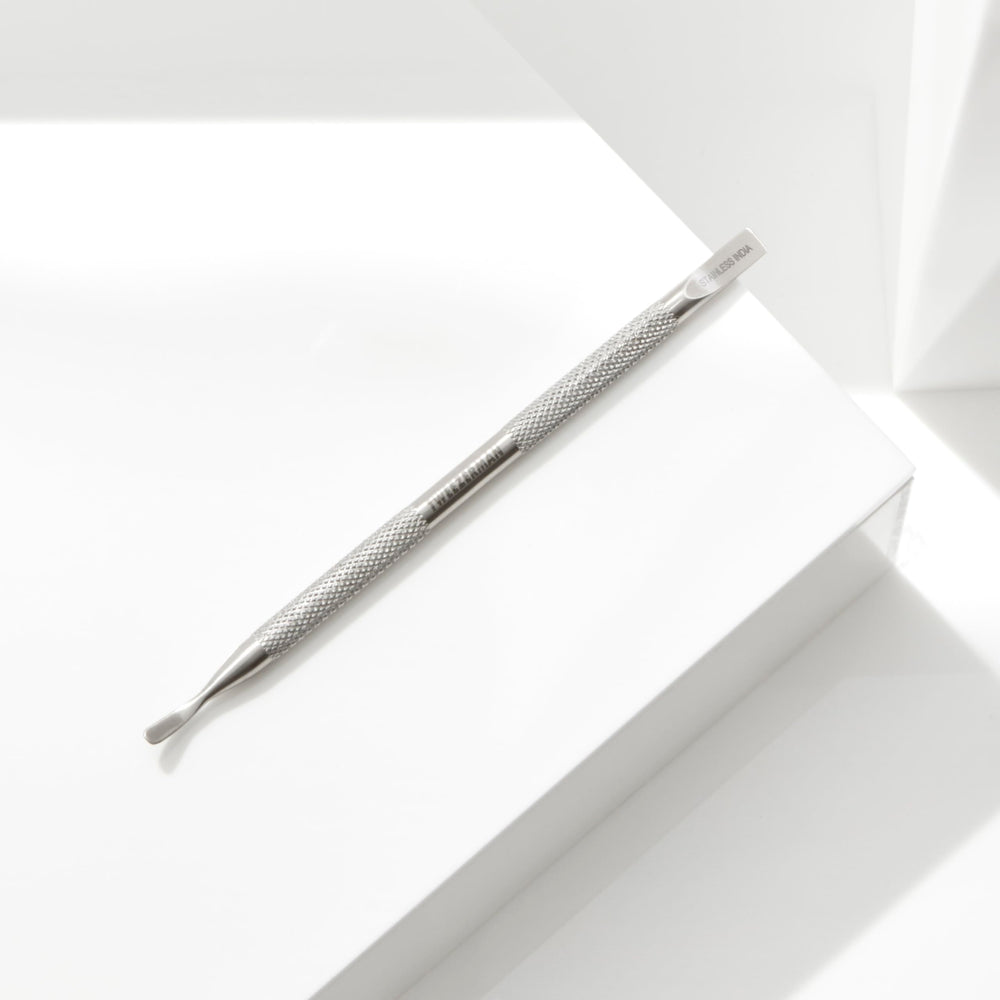 Tweezerman Pushy held beside fingers to show tool scale and accurate maneuvering