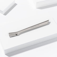 Tweezerman razor held in hand to show compact size and travel convenience