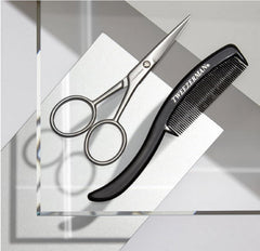 Tweezerman scissors held in hand demonstrating scale and ergonomic control for accurate snips