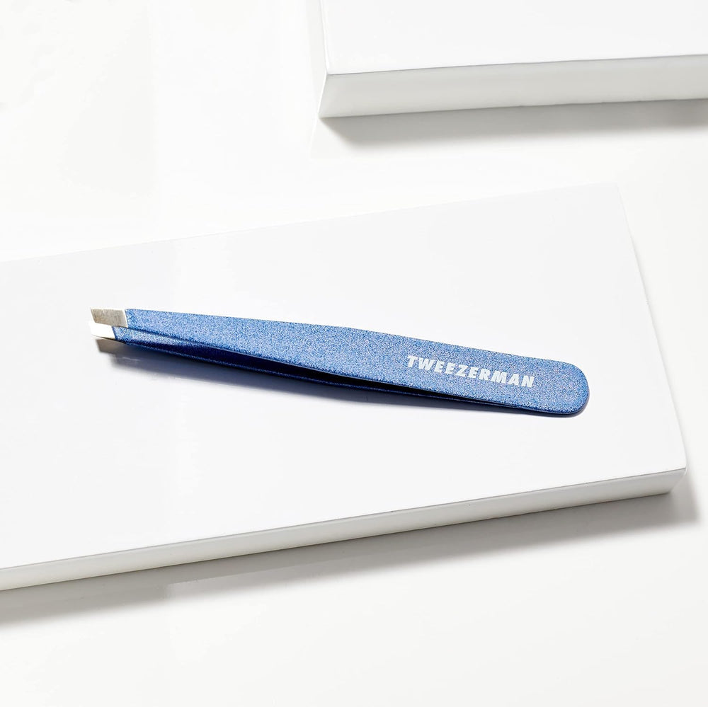 Tweezerman tweezer in use removing stray brow hair demonstrating precision benefit: clean root removal